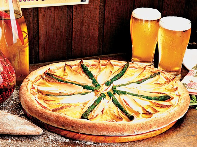 Pizza com queijo brie, endívia e aspargo fresco borrifados por azeite de trufa sobre a massa média Pizza com queijo brie, endívia e aspargo fresco borrifados por azeite de trufa sobre a massa média