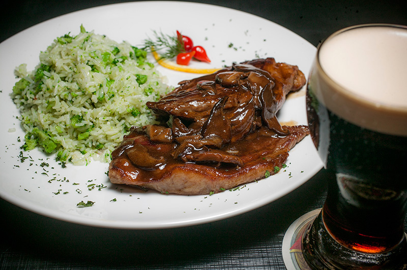 Coberta por pedaços de cogumelo shiitake e molho madeira, a picanha vem com arroz de brócolis