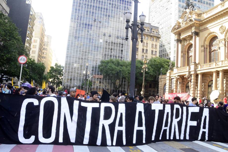 Manifestantes do Movimento Passe Livre erguem faixa em frente ao Municipal