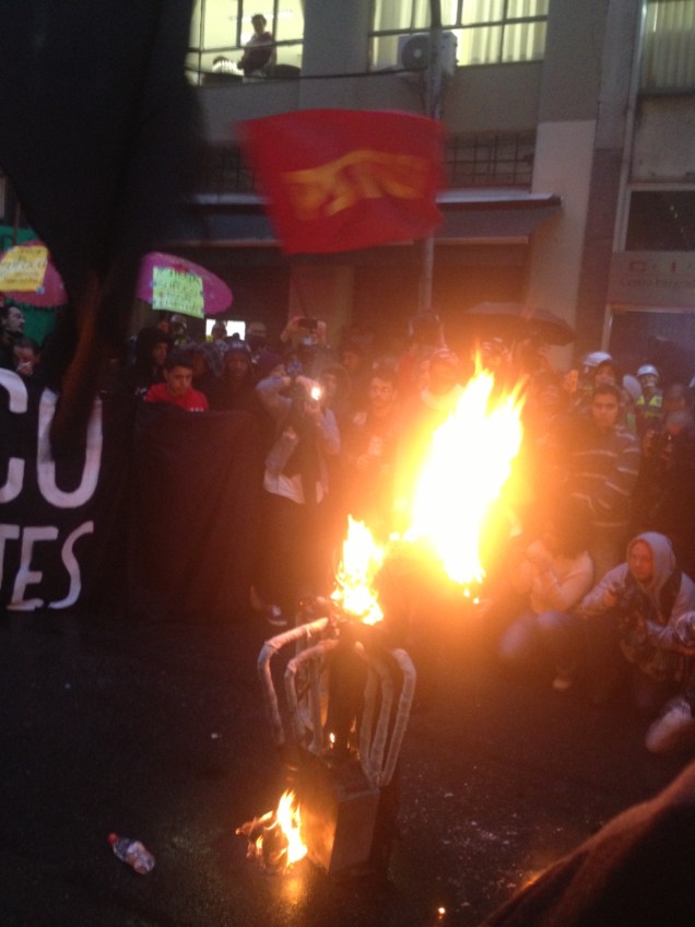 	Em frente &agrave; Secretaria dos Transportes, os manifestantes atearam fogo em uma catraca de &ocirc;nibus falsa. O ato segue pac&iacute;fico