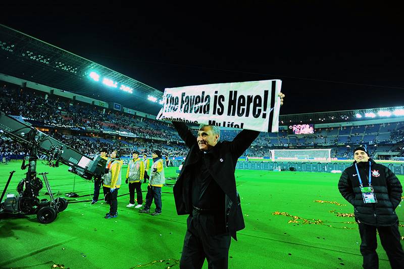 O técnico Tite ergueu a faixa "The Favela is Here" O técnico Tite ergueu a faixa "The Favela is Here"