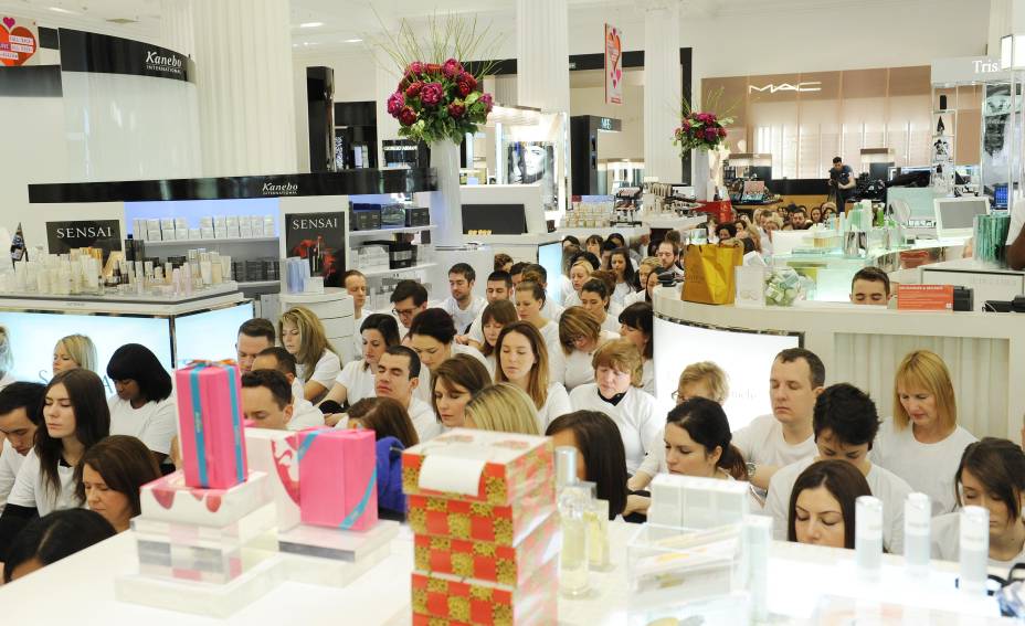 Funcionários e clientes meditam juntos no meio da loja Funcionários e clientes meditam juntos no meio da loja