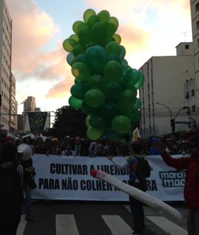 Na frente da passeata, alguns grandes cartazes diziam "cultivar a liberdade para n&atilde;o colher a guerra"