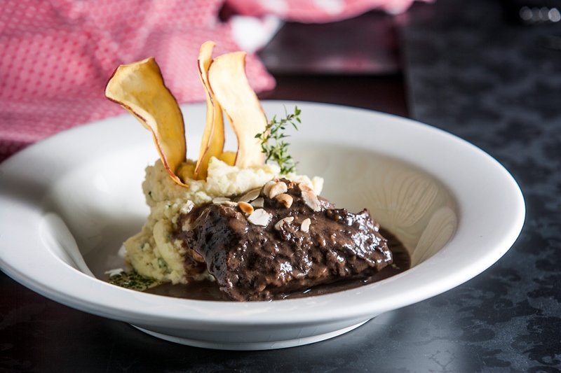 A bochecha bovina vai ao fogo para cozinhar no vinho tinto e ganha purê de batata-doce de guarnição