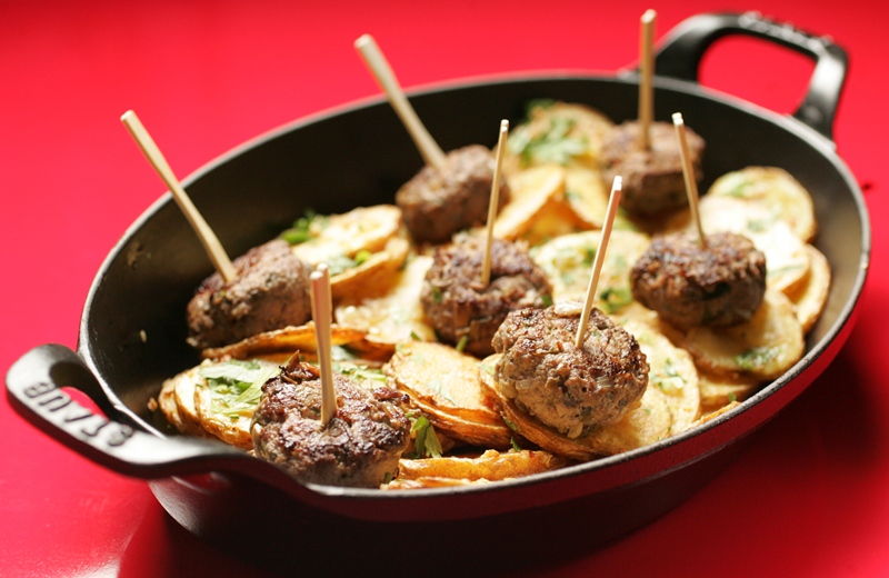 A deliciosa porção de mini-hambúrgueres com batata sautée vem na panela, a cocotte A deliciosa porção de mini-hambúrgueres com batata sautée vem na panela, a cocotte