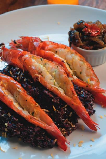 Trio de camarões sobre arroz negro Trio de camarões sobre arroz negro