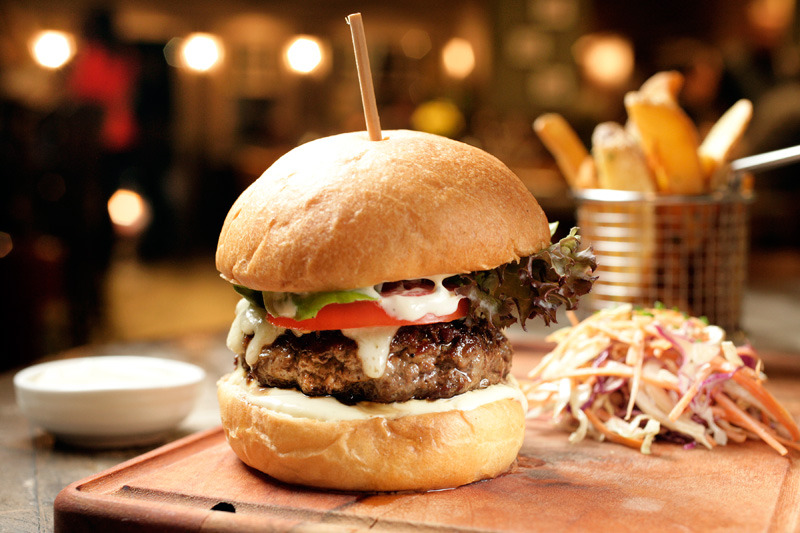 Hambúrguer de angus com queijo raclete e salada no pão feito na casa Hambúrguer de angus com queijo raclete e salada no pão feito na casa