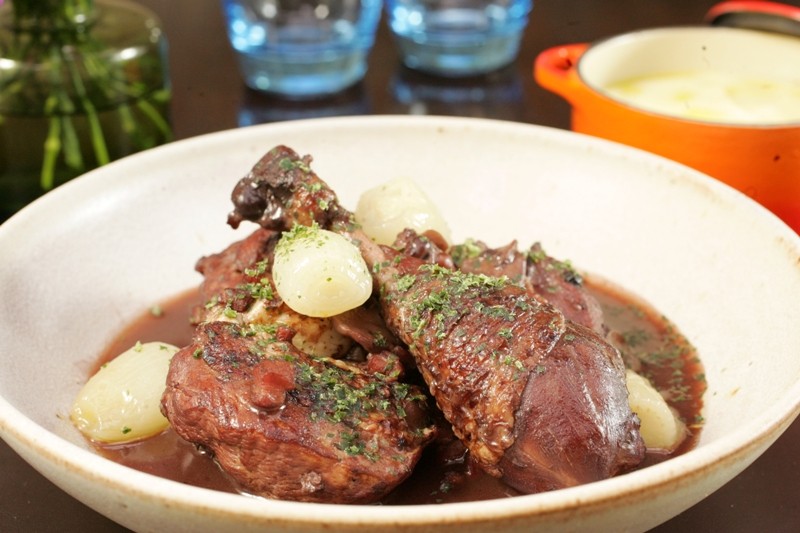 No francês L’Amitié: coq au vin feito de galinha caipira cozida em vinho tinto No francês L’Amitié: coq au vin feito de galinha caipira cozida em vinho tinto