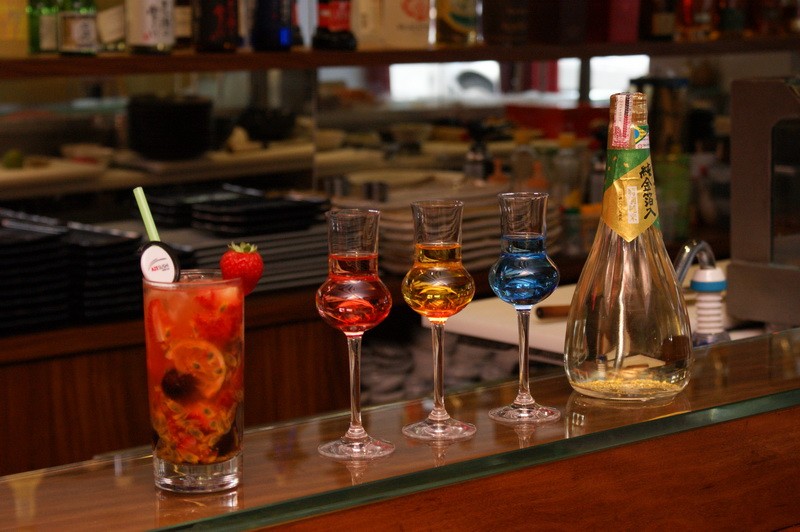 Sakerinha (Coquetel Típico da Casa), sakês tradicionais e garrafa de sakê com bolinhas de ouro Sakerinha (Coquetel Típico da Casa), sakês tradicionais e garrafa de sakê com bolinhas de ouro