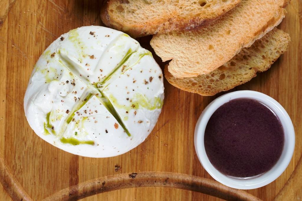 A burrata vem acompanhada de tapenade e torradas A burrata vem acompanhada de tapenade e torradas