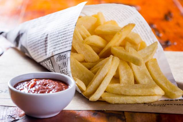 A porção de batatas fritas no cone A porção de batatas fritas no cone