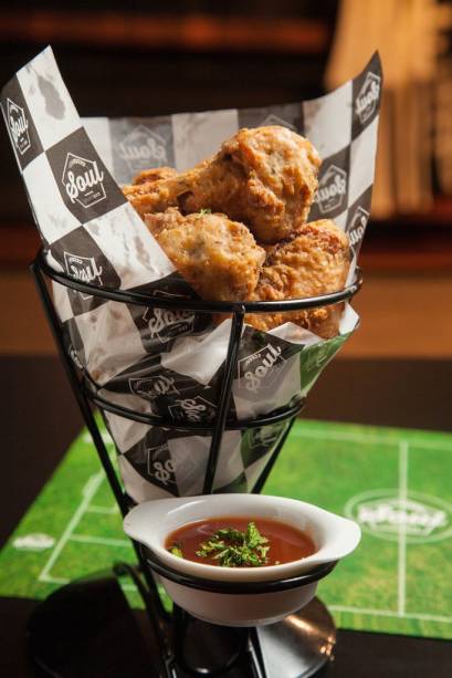 Na hora de petiscar, agrada a porção de buffalo wings, asinhas de frango fritas aqui com o molho picante à parte