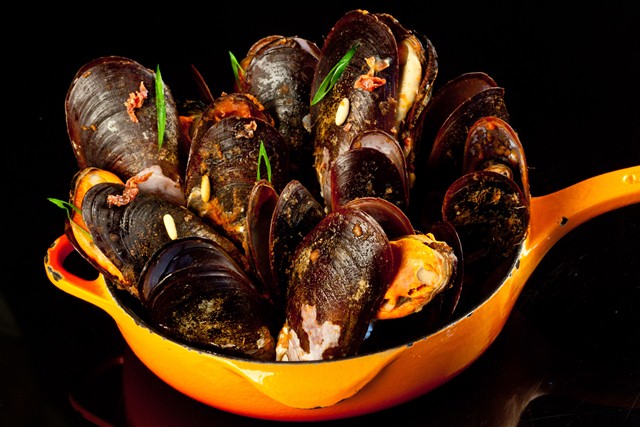 Frigideira de Mexilhões de areia puxados em vinho branco com sugo de tomates, Jamom serrano e pinólis Frigideira de Mexilhões de areia puxados em vinho branco com sugo de tomates, Jamom serrano e pinólis