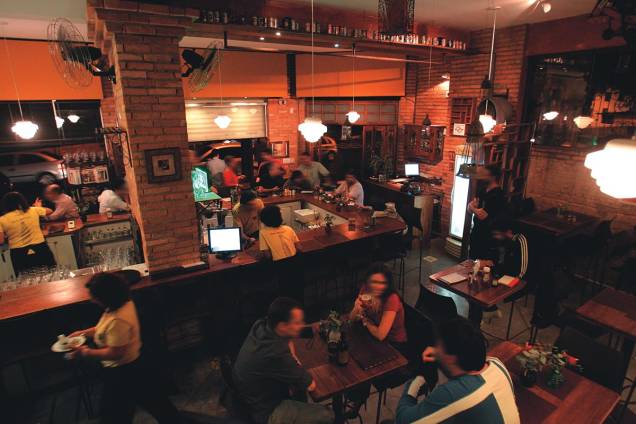 Espaço rústico: balcão com dezoito lugares e mesas de estilo bistrô Espaço rústico: balcão com dezoito lugares e mesas de estilo bistrô