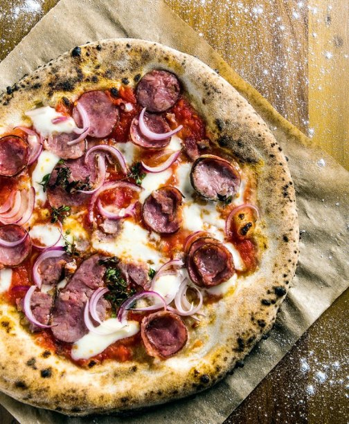 A pizza de calabresa, cebola-roxa, mussarela e orégano fresco A pizza de calabresa, cebola-roxa, mussarela e orégano fresco
