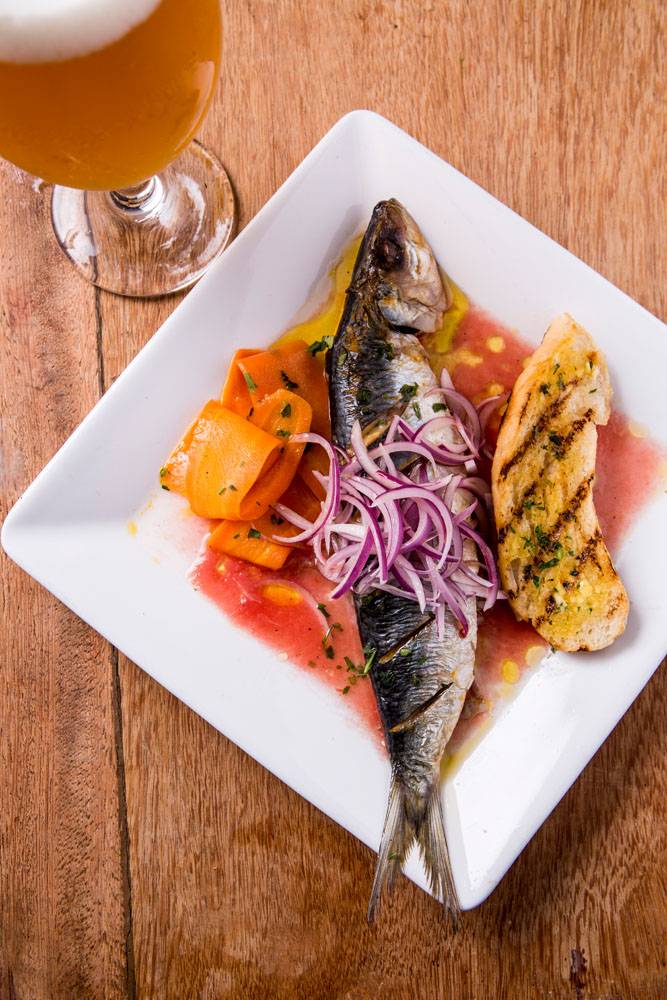 Sardinha escabeche reinterpretada: frita e coberta por cebola-roxa e molho de tomate Sardinha escabeche reinterpretada: frita e coberta por cebola-roxa e molho de tomate