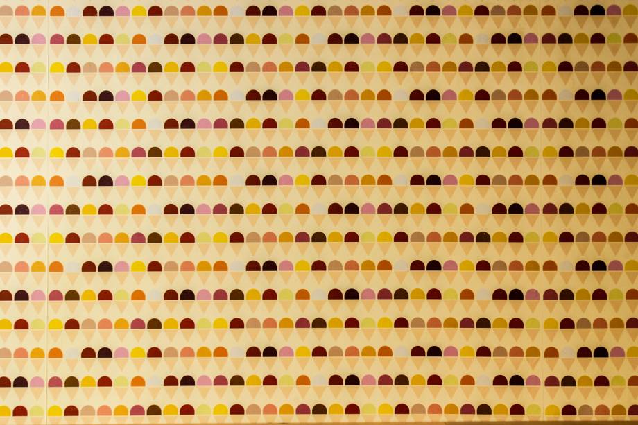 Detalhe gracioso de uma das laterais revestida com papel de parede texturizado em forma de casquinhas de sorvete Detalhe gracioso de uma das laterais revestida com papel de parede texturizado em forma de casquinhas de sorvete