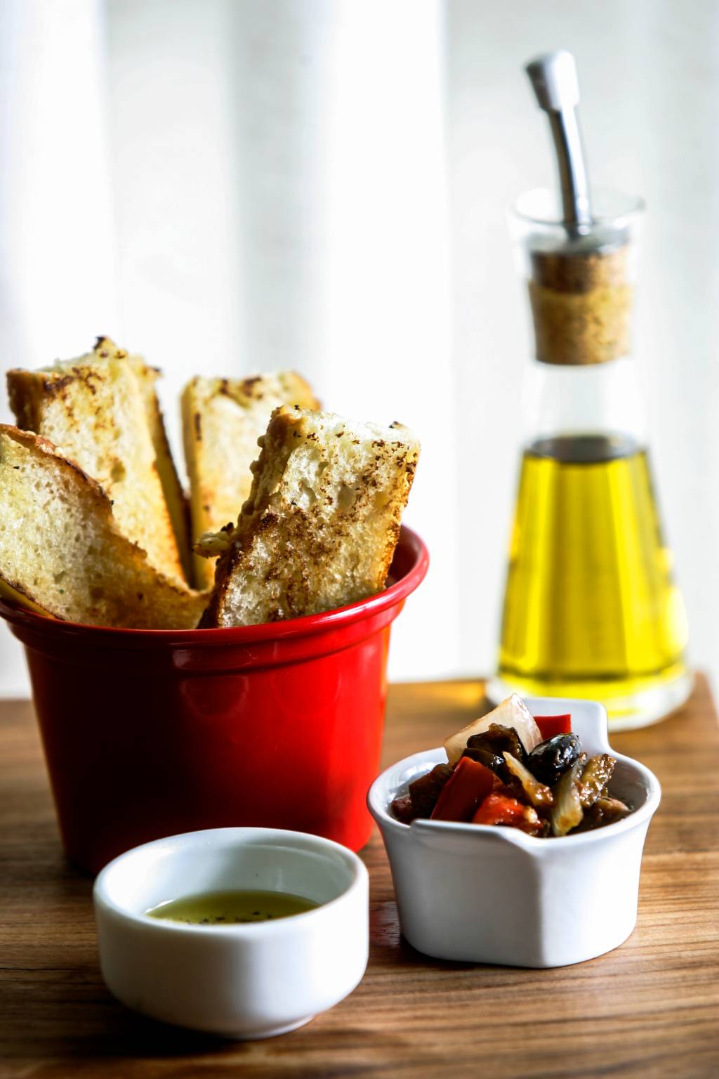 O couvert compõe-se de focaccia grelhada, caponata e azeite temperado com vinagre balsâmico O couvert compõe-se de focaccia grelhada, caponata e azeite temperado com vinagre balsâmico