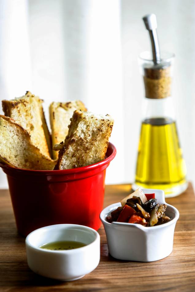 O couvert compõe-se de focaccia grelhada, caponata e azeite temperado com vinagre balsâmico O couvert compõe-se de focaccia grelhada, caponata e azeite temperado com vinagre balsâmico
