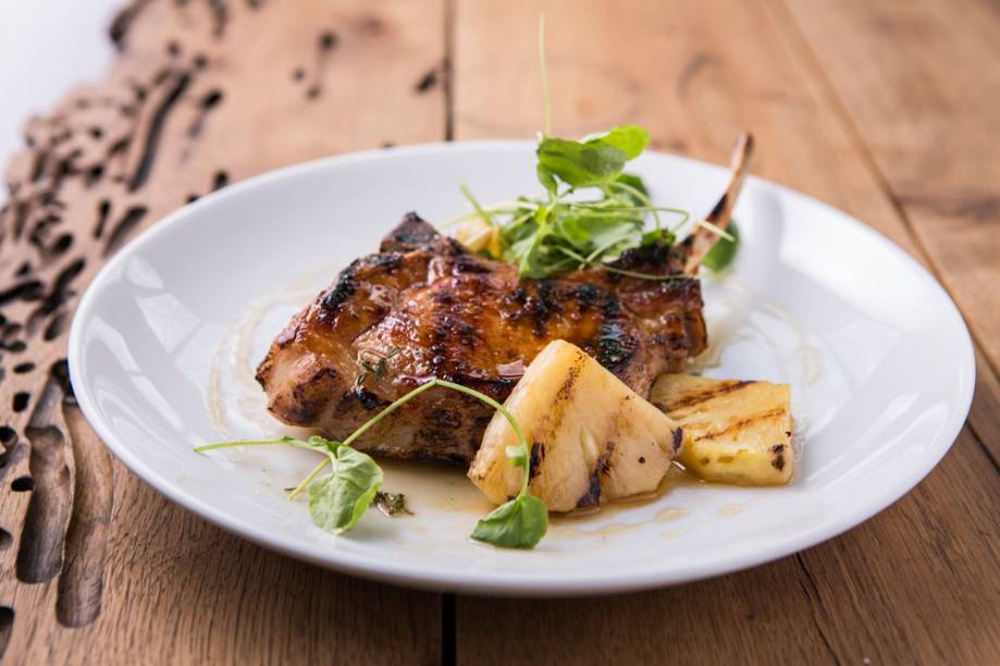 A bisteca suína recebe a companhia de abacaxi igualmente grelhado A bisteca suína recebe a companhia de abacaxi igualmente grelhado