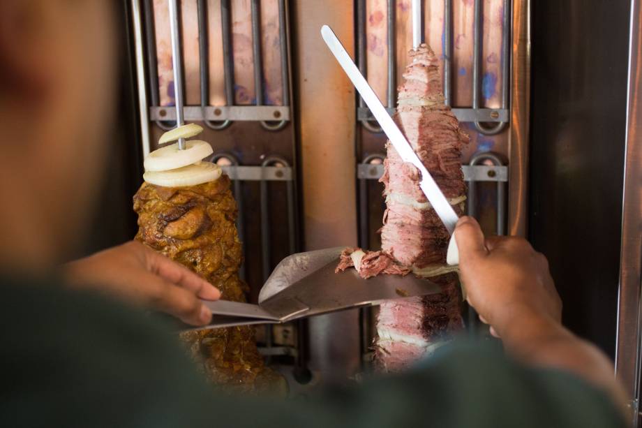O chawarma é preparado no espeto giratório, ao lado do parguit, um duo de coxa e sobrecoxa de frango O chawarma é preparado no espeto giratório, ao lado do parguit, um duo de coxa e sobrecoxa de frango