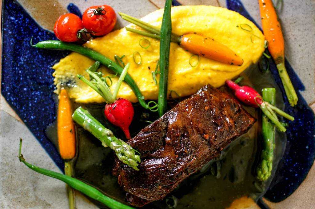 A paleta de cordeiro com leguminhos chega guarnecida de massa ou de polenta A paleta de cordeiro com leguminhos chega guarnecida de massa ou de polenta