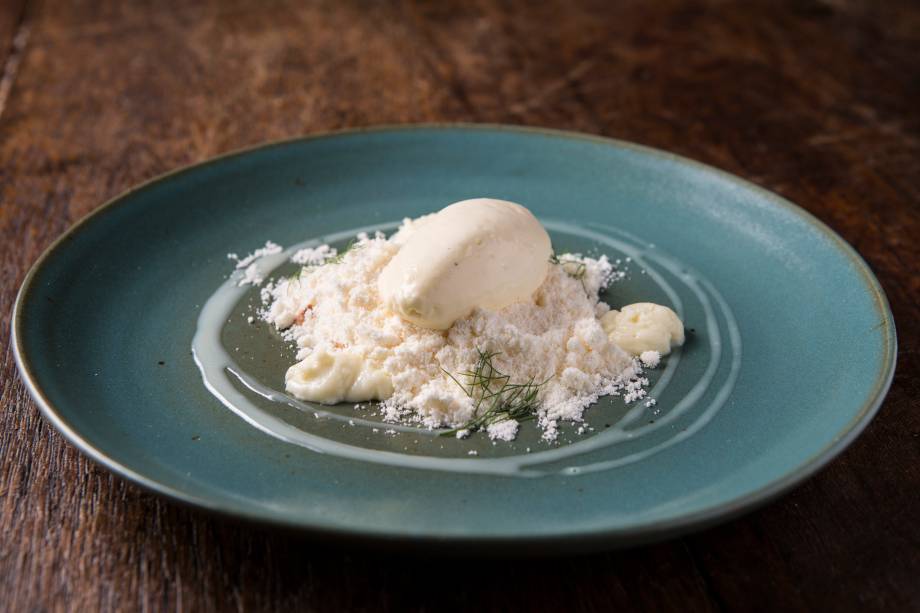 Sobremesa de areia de baunilha sobre um maracujá, castanha-de-caju e sorvete de chocolate branco