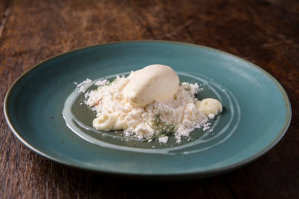 Sobremesa de areia de baunilha sobre um maracujá, castanha-de-caju e sorvete de chocolate branco Sobremesa de areia de baunilha sobre um maracujá, castanha-de-caju e sorvete de chocolate branco