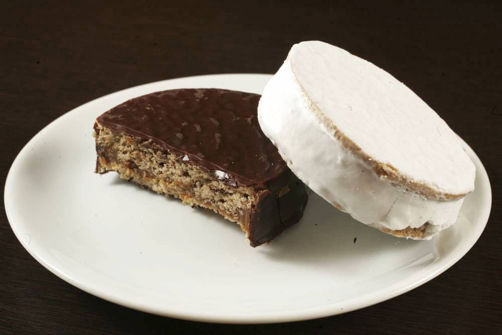 Cappuccino e alfajores com cobertura de chocolate e de merengue