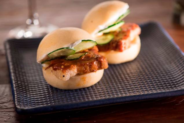 Hirá buns: dupla de pães no vapor recheados de barriga de porco, pepino, molho de missô com pimenta e aïoli com leite Hirá buns: dupla de pães no vapor recheados de barriga de porco, pepino, molho de missô com pimenta e aïoli com leite