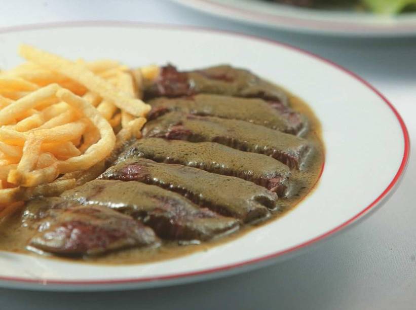 No entrecôte, único prato no cardápio, o bife de contrafilé é coberto por um molho untuoso e acompanhado de fritas No entrecôte, único prato no cardápio, o bife de contrafilé é coberto por um molho untuoso e acompanhado de fritas