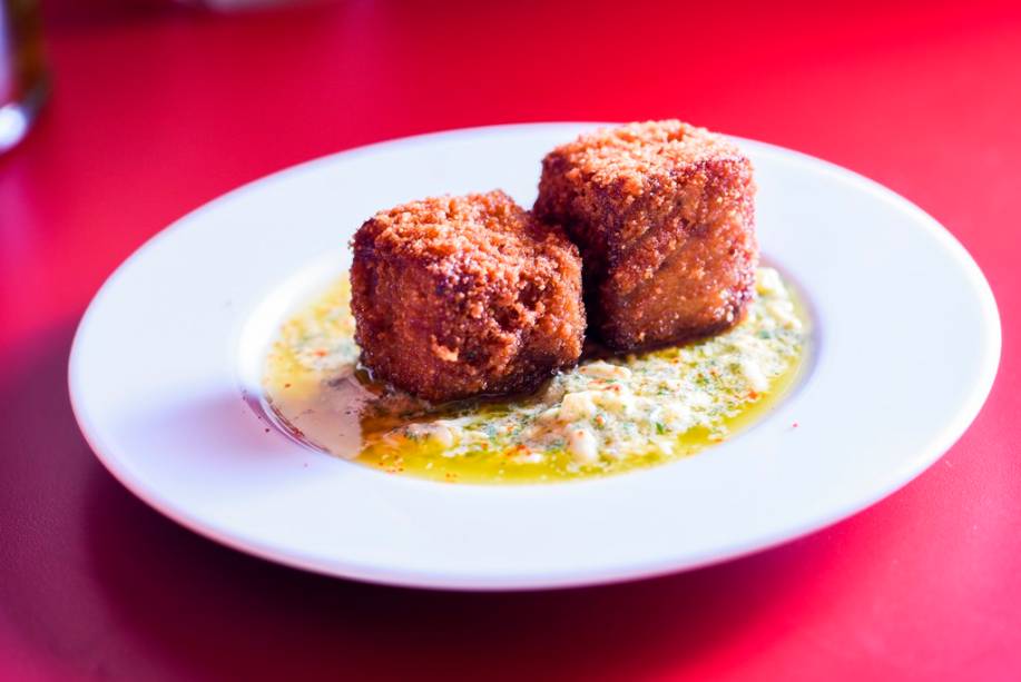 O par de croquetes de pé de porco com linguiça prepara o paladar para o próximo gole O par de croquetes de pé de porco com linguiça prepara o paladar para o próximo gole