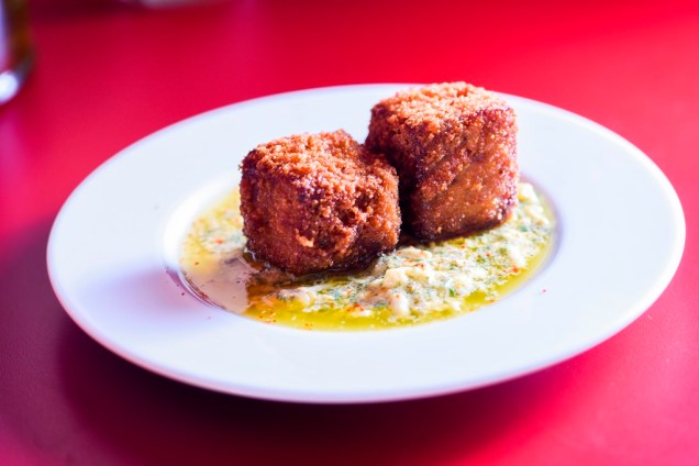 O par de croquetes de pé de porco com linguiça prepara o paladar para o próximo gole O par de croquetes de pé de porco com linguiça prepara o paladar para o próximo gole