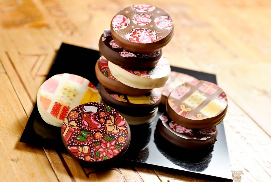Le Vin Patisserie: biscoitos decorados cobertos por chocolate ao leite ou branco e recheados de doce de leite Le Vin Patisserie: biscoitos decorados cobertos por chocolate ao leite ou branco e recheados de doce de leite