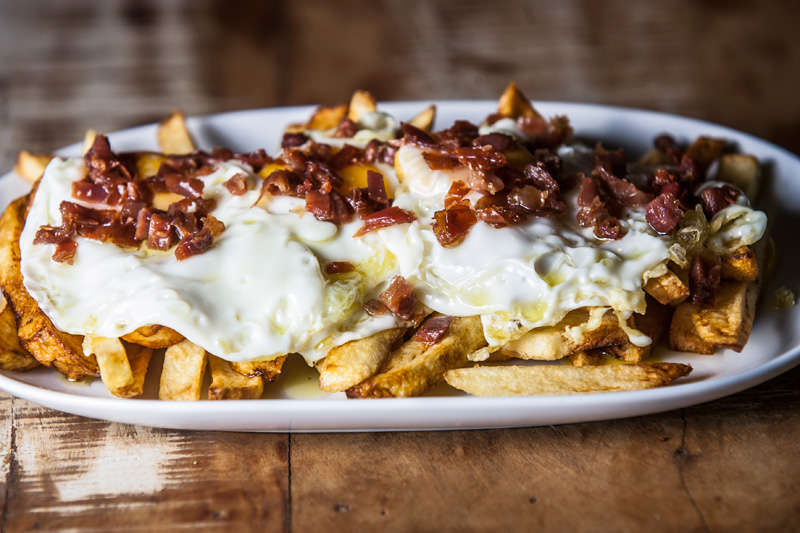 Huevos como los de lucio: ovos estrelados salpicados de crisps de jamón sobre batatas em gomos Huevos como los de lucio: ovos estrelados salpicados de crisps de jamón sobre batatas em gomos