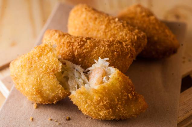 De petisco, quarteto de pedaços gorduchos de bacalhau empanado De petisco, quarteto de pedaços gorduchos de bacalhau empanado
