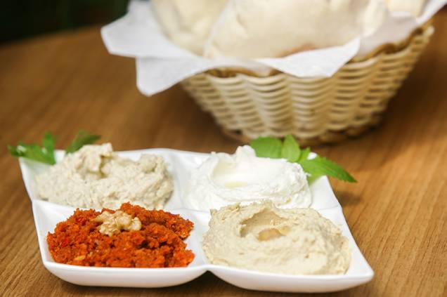 No quarteto de pastas vão muhamara (pasta de pimentão vermelho), babaganuche (berinjela), coalhada seca e homus (grão-de-bico) No quarteto de pastas vão muhamara (pasta de pimentão vermelho), babaganuche (berinjela), coalhada seca e homus (grão-de-bico)