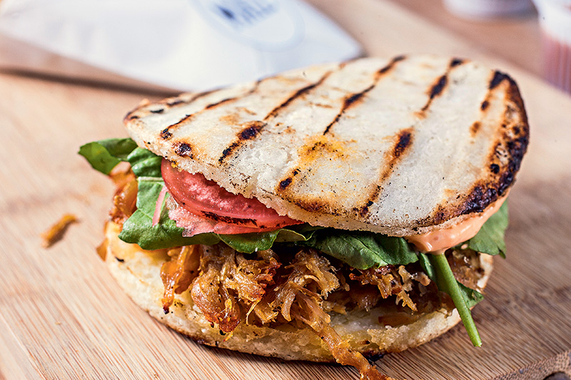 Bom e barato: arepa de pernil, rúcula, conserva de rabanete e maionese apimentada Bom e barato: arepa de pernil, rúcula, conserva de rabanete e maionese apimentada