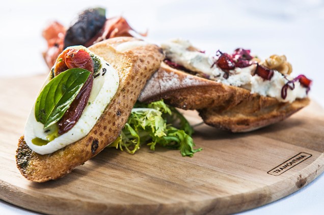 A meia-porção de bruschetta do cardápio é servida em trios A meia-porção de bruschetta do cardápio é servida em trios