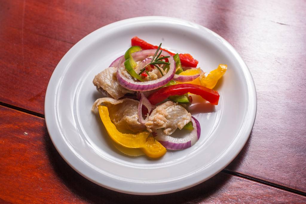 Ceviche com cebola-roxa e pimentôes: o peixe branco perde sua textura por ser apresentado em tiras finas, não cubos Ceviche com cebola-roxa e pimentôes: o peixe branco perde sua textura por ser apresentado em tiras finas, não cubos