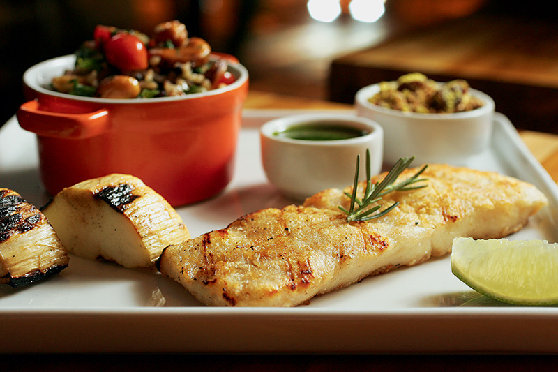 Pirarucu servido na companhia de palmito pupunha grelhado, molho de rúcula e arroz de espinafre com castanha-de-caju e tomatinhos Pirarucu servido na companhia de palmito pupunha grelhado, molho de rúcula e arroz de espinafre com castanha-de-caju e tomatinhos
