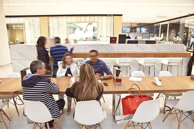 No quiosque no Shopping JK Iguatemi, há uma mesa comunitária para dezesseis pessoas No quiosque no Shopping JK Iguatemi, há uma mesa comunitária para dezesseis pessoas