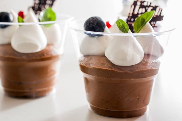 Musse de chocolate meio amargo coberta por chantili, folhas de manjericão-anão, semente de romã e mirtilo Musse de chocolate meio amargo coberta por chantili, folhas de manjericão-anão, semente de romã e mirtilo