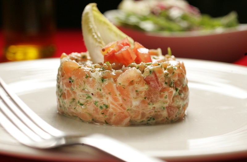 O tartare de salmão é temperado com limão-siciliano e ervas frescas O tartare de salmão é temperado com limão-siciliano e ervas frescas