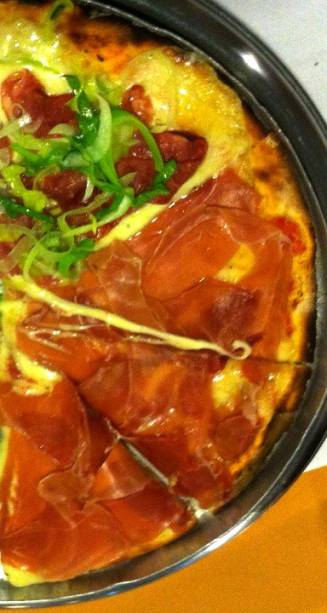 Pizza de presunto cru sobre mussarela de búfala e de calabresa de javali, mussarela de búfala e alho-poró refogado Pizza de presunto cru sobre mussarela de búfala e de calabresa de javali, mussarela de búfala e alho-poró refogado