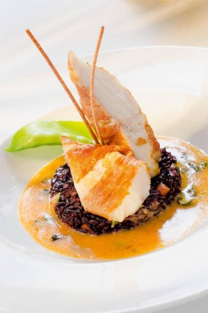 Peixe tamboril: envolto em presunto cru com emulsão de sálvia e arroz negro Peixe tamboril: envolto em presunto cru com emulsão de sálvia e arroz negro