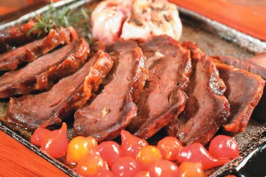 Uma das campeãs de pedidos do brasileiro Mocotó: carne de sol na chapa com alho assado, pimenta-biquinho e chips de mandioca Uma das campeãs de pedidos do brasileiro Mocotó: carne de sol na chapa com alho assado, pimenta-biquinho e chips de mandioca