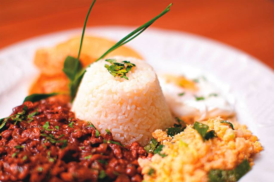 O picadinho com ovo poché, farofa, batata e arroz O picadinho com ovo poché, farofa, batata e arroz