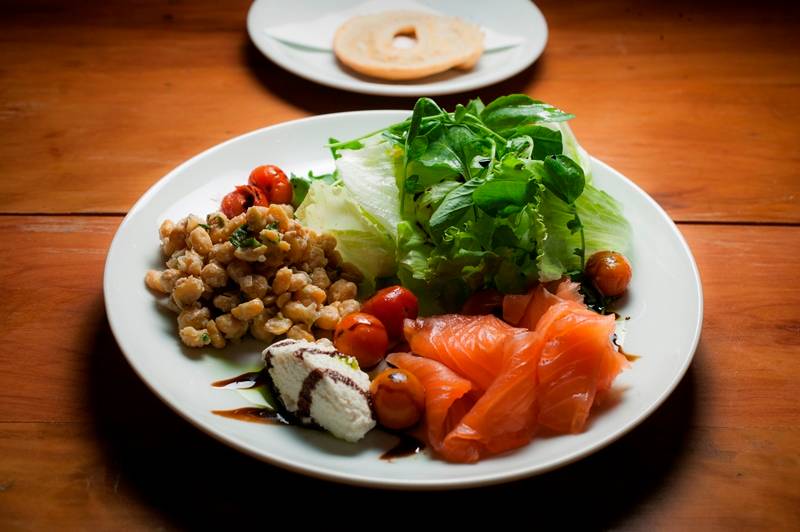 Salmão lox: salada verde com o peixe defumado, grão-de-bico e torrada de bagel Salmão lox: salada verde com o peixe defumado, grão-de-bico e torrada de bagel