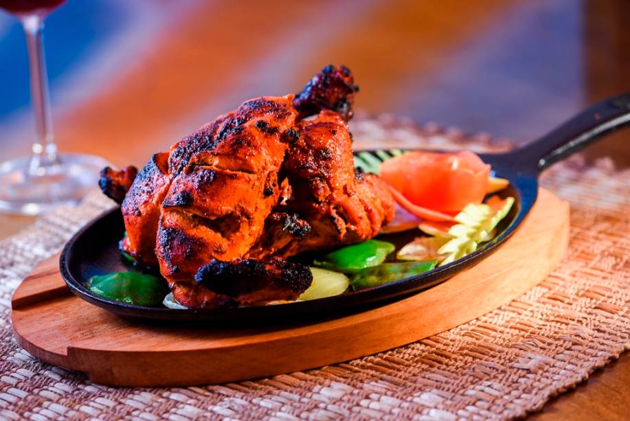 O franguinho ao curry vermelho no forno tandoor é combinado a cebola-roxa e pimentão na chapa O franguinho ao curry vermelho no forno tandoor é combinado a cebola-roxa e pimentão na chapa